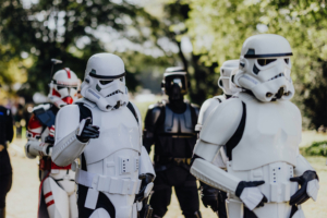 501st Legion Stormtrooper-Cosplayer in detaillierten Kostümen beim Elbenwald Festival, umgeben von weiteren Star Wars-Figuren. Die Veranstaltung kombiniert Musik und Nerdkultur in einer lebendigen Festivalatmosphäre im Freien.