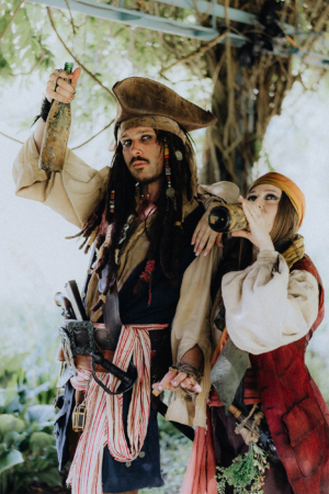 Zwei kostümierte Piraten posieren auf dem Elbenwald Festival, der eine mit einer Flasche in der Hand und der andere mit einem Trinkgefäß. Die Szene zeigt die kreative und fantasievolle Atmosphäre des Festivals, das Musik und Nerd-Kultur vereint.