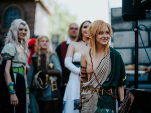 Cosplayer auf dem Elbenwald Festival, gekleidet in fantasievolle Kostüme, die Charaktere aus beliebten Nerd-Universen darstellen. Die lebendige Atmosphäre und die Vielfalt der Teilnehmer schaffen ein einzigartiges Erlebnis für Fans der Popkultur.