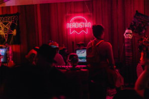 Gamesroom by Nerdistan Bunte Szenerie im Nerdistan-Bereich des Elbenwald Festivals, mit neonfarbener Beleuchtung, Retro-Gaming-Elementen und kreativen Kostümen. Besucher genießen die entspannte Atmosphäre und die vielfältigen Aktivitäten in einem nerdigen Ambiente.