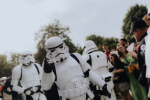 501st Legion Stormtrooper-Kostüme auf dem Elbenwald Festival, umgeben von begeisterten Fans in bunten Outfits. Die Szene zeigt die Verbindung von Musik, Cosplay und nerdiger Kultur in einer lebhaften Festivalatmosphäre.