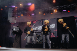 Auftritt der Cantina Band beim Elbenwald Festival, mit Künstlern in auffälligen Masken und Kostümen, die auf der Bühne musizieren. Im Hintergrund sind Instrumente und Bühnenlichter sichtbar, die zur lebhaften Atmosphäre des Festivals beitragen.