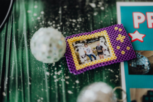 Retro-Basteln Bunte Fotografie in einem Perlenrahmen, die drei Personen zeigt, die mit Stormtroopern posieren, umgeben von glitzernden Disco-Kugeln und einem festlichen Hintergrund. Ideal für das Elbenwald Festival, das Musik und Nerdkultur vereint.