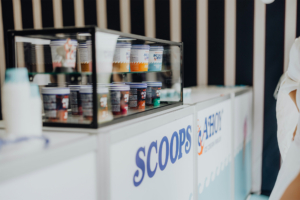 Scoops Ahoy Eiscreme-Stand auf dem Elbenwald Festival mit bunten Bechern in einer Vitrine. Die Registrierung zeigt kreative Sorten und ein einladendes Design, das die Festivalbesucher anspricht und das kulinarische Erlebnis bereichert.
