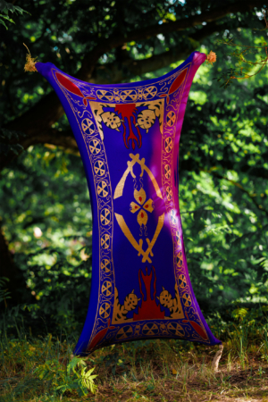 Bunt gestaltetes Zelt mit goldenen und roten Mustern, auf dem Elbenwald Festival aufgestellt. Umgeben von grüner Natur, bietet es einen einzigartigen Blickfang für Festivalbesucher und verkörpert die kreative Atmosphäre der Veranstaltung.
